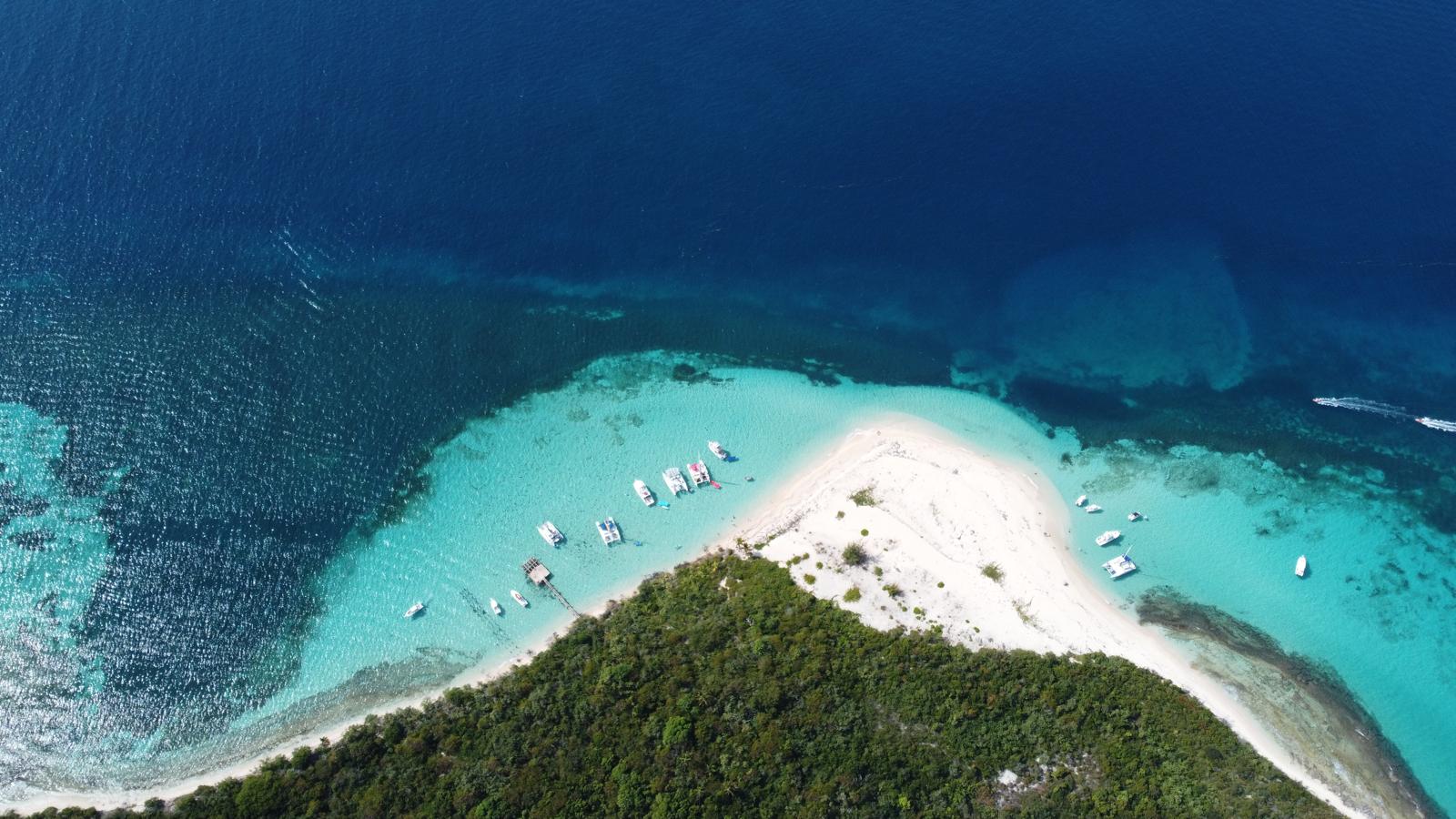 Boat anchored near a sandy beach with clear blue water at Icacos Nature Reserve
